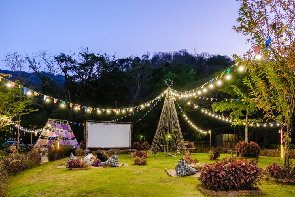 outdoor cinema film in a tropical garden with christmas lights